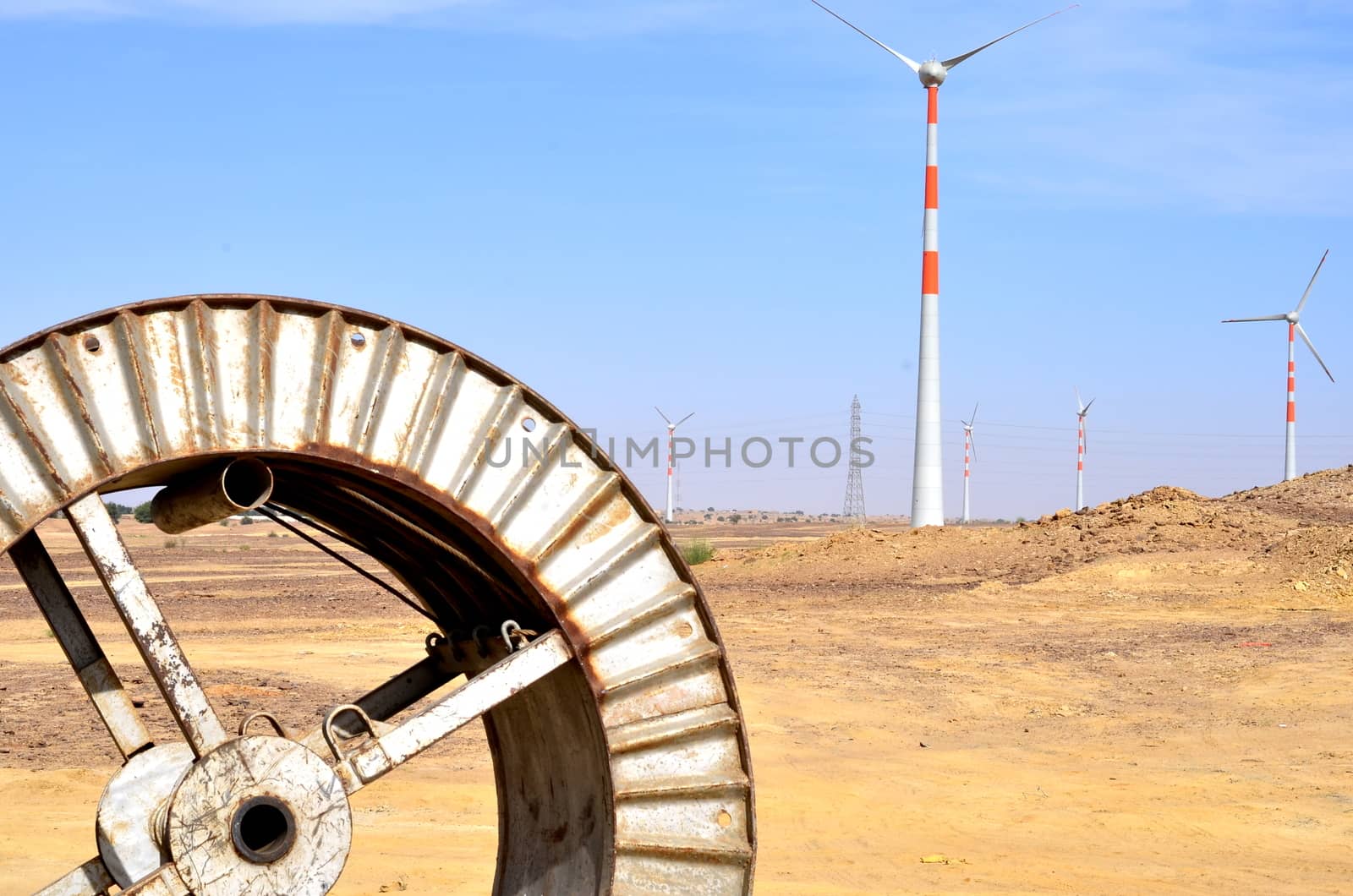 Windmills in the backdrop of a winding wheel on the way to Sam Sand Dunes (Thar Desert) from Jaisalmer, Rajasthan, India. The Jaisalmer Wind Park is India's 2nd largest operational onshore wind farm. by jayantbahel