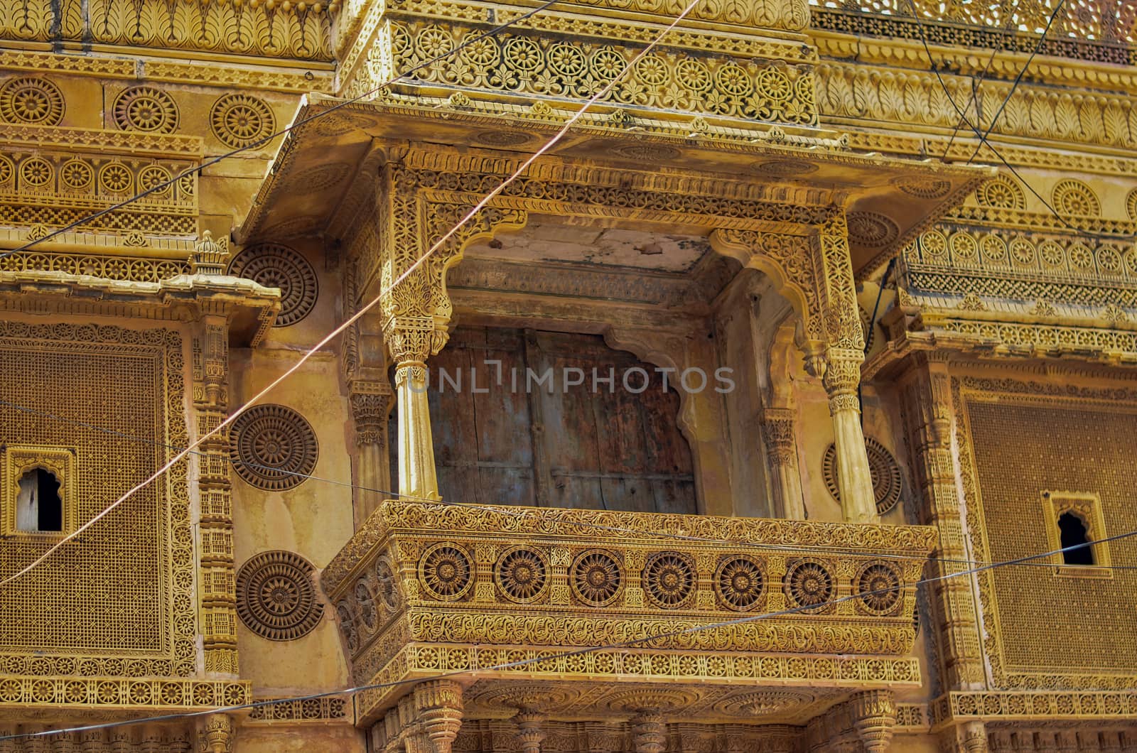 Traditional Rajasthani haveli with a decorated window at Patwon ki haveli in Jaisalmer, Rajasthan, India. Series of early-1800s palaces, now a museum featuring intricate carvings, furniture & artwork. by jayantbahel