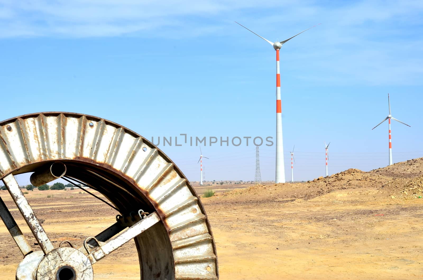 Windmills in the backdrop of a winding wheel on the way to Sam Sand Dunes (Thar Desert) from Jaisalmer, Rajasthan, India. The Jaisalmer Wind Park is India's 2nd largest operational onshore wind farm. by jayantbahel