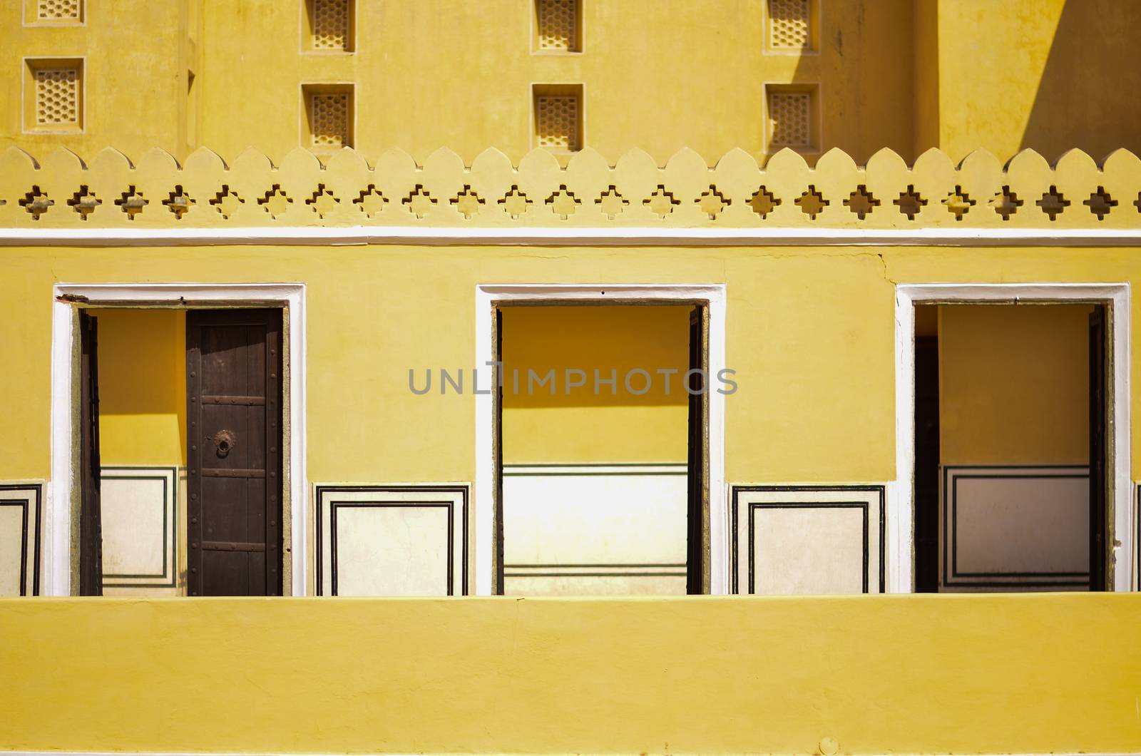 Yellow balcony with three open doors inside Hawa Mahal in Jaipur, Rajasthan, India. It is a palace which is constructed of red and pink sandstone, built in 1799 by Maharaja Sawai Pratap Singh by jayantbahel