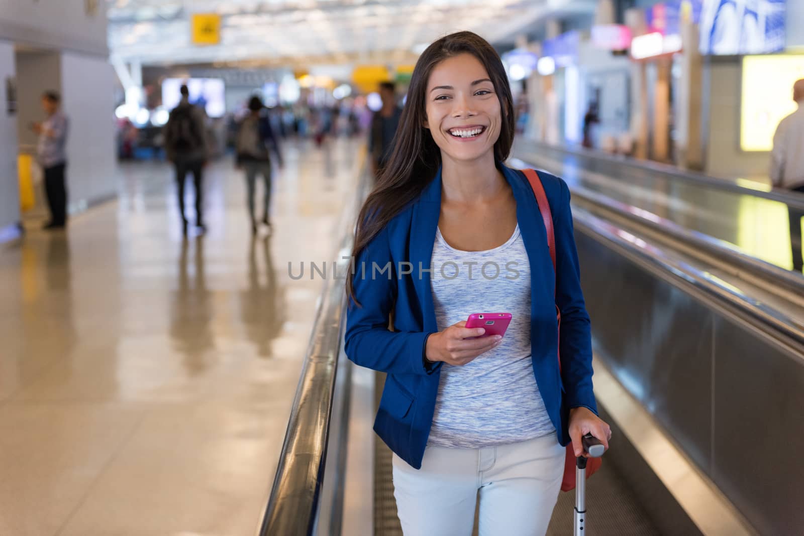 Travel woman using smartphone at airport. Young asian traveler holding mobile phone app in terminal or train station. Tourist businesswoman on commute or vacation.