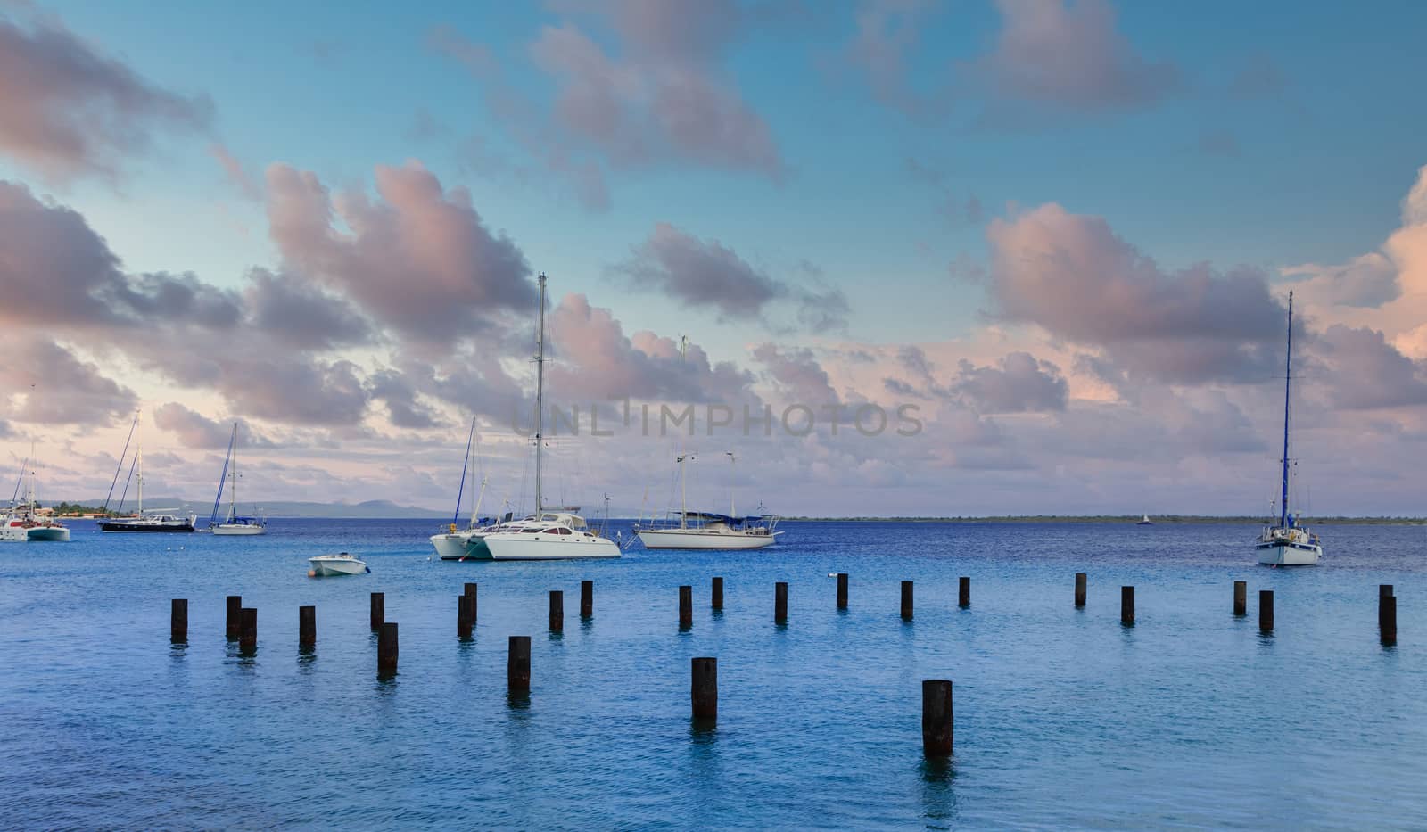 Sailboats Past Pilings in Bonaire by dbvirago