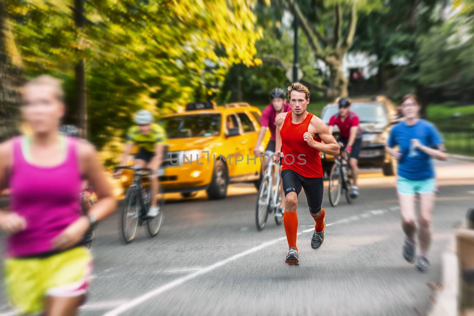 Runner athlete man running in run marathon race in Central Park New York city. People crowd jogging in street urban active lifestyle. Motion blur focus on one person by Maridav