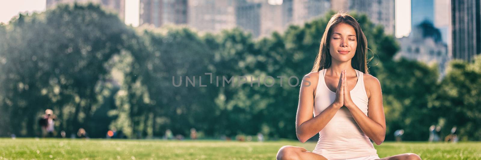 Yoga woman meditation praying outside in city park wellness banner panorama .Summer exercise lifestyle active young Asian girl meditating background.