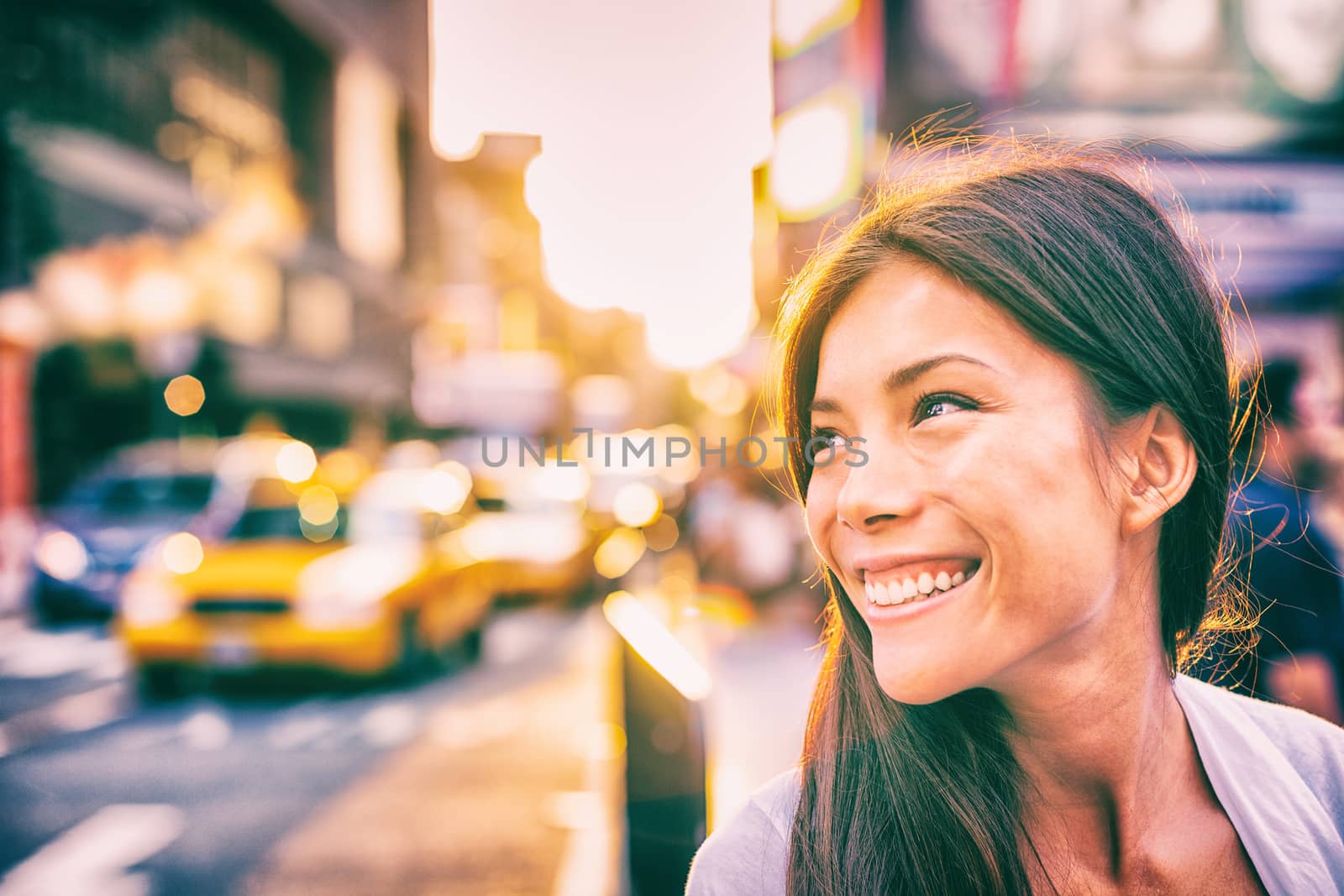 Happy people New York city lifestyle young Asian woman smiling in sunset walking in street with taxi cabs traffic sun shining down in downtown Manhattan, New York City by Maridav