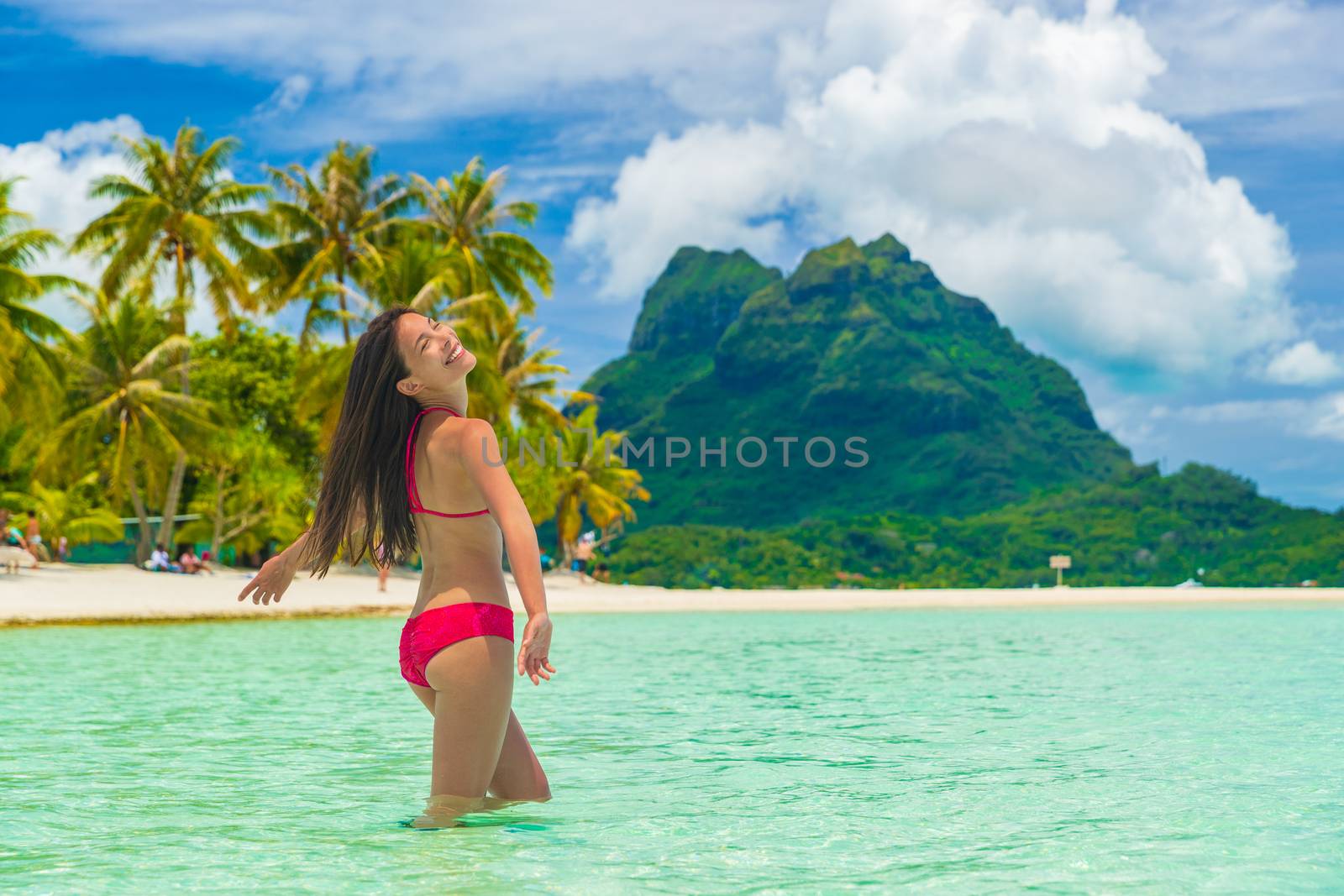 Bora bora luxury vacation travel paradise bikini woman swimming at island in Tahiti, French Polynesia. Popular honeymoon destination holiday in South Pacific, Oceania.