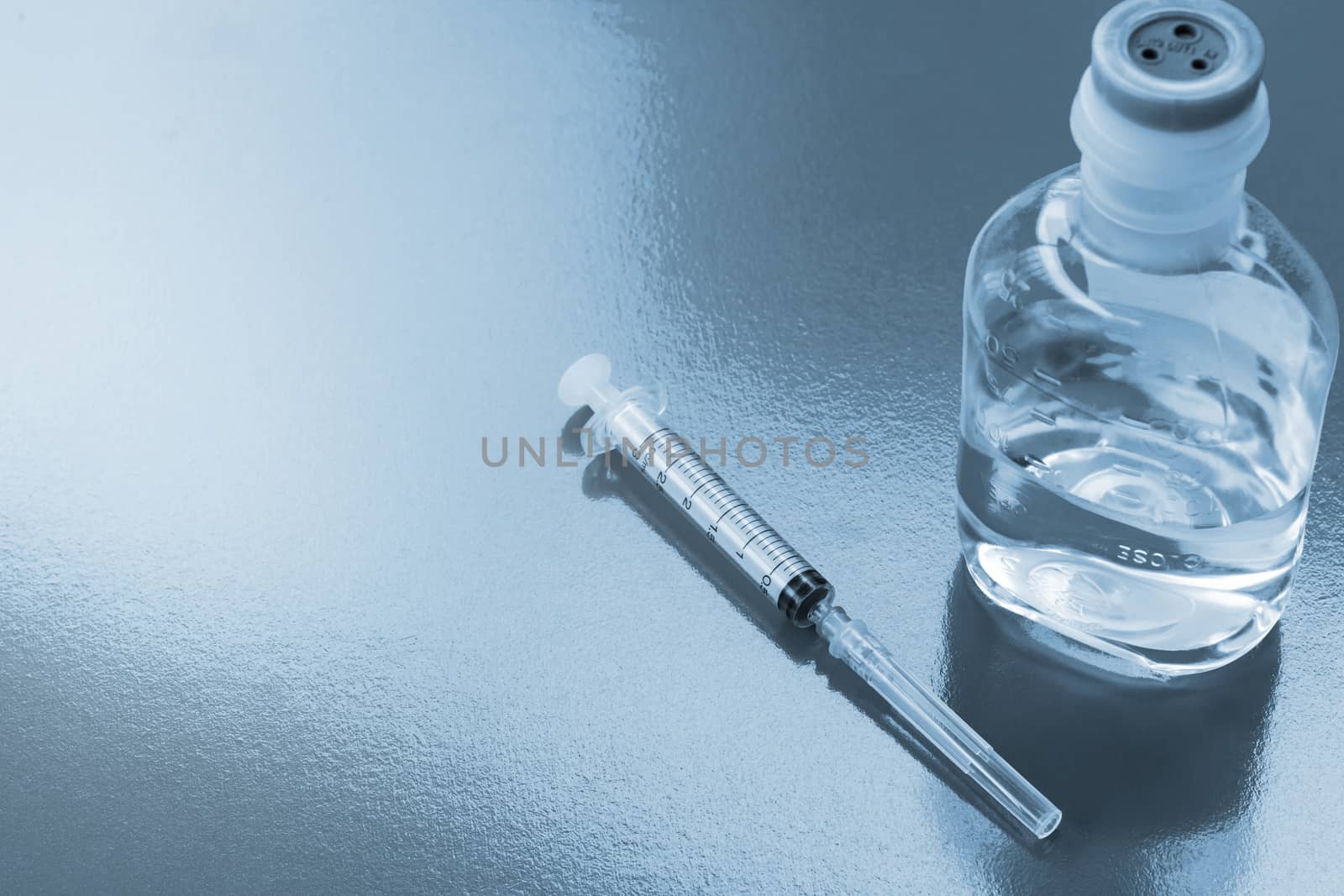 Syringe or injection needle on blue background, medical and health care concept