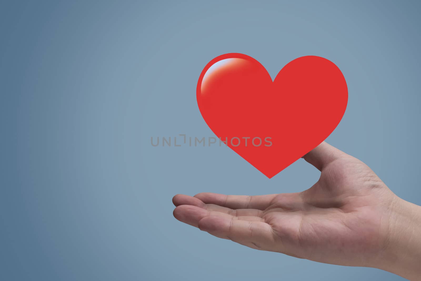 Health care and insurance concept, heart and hand on blue background