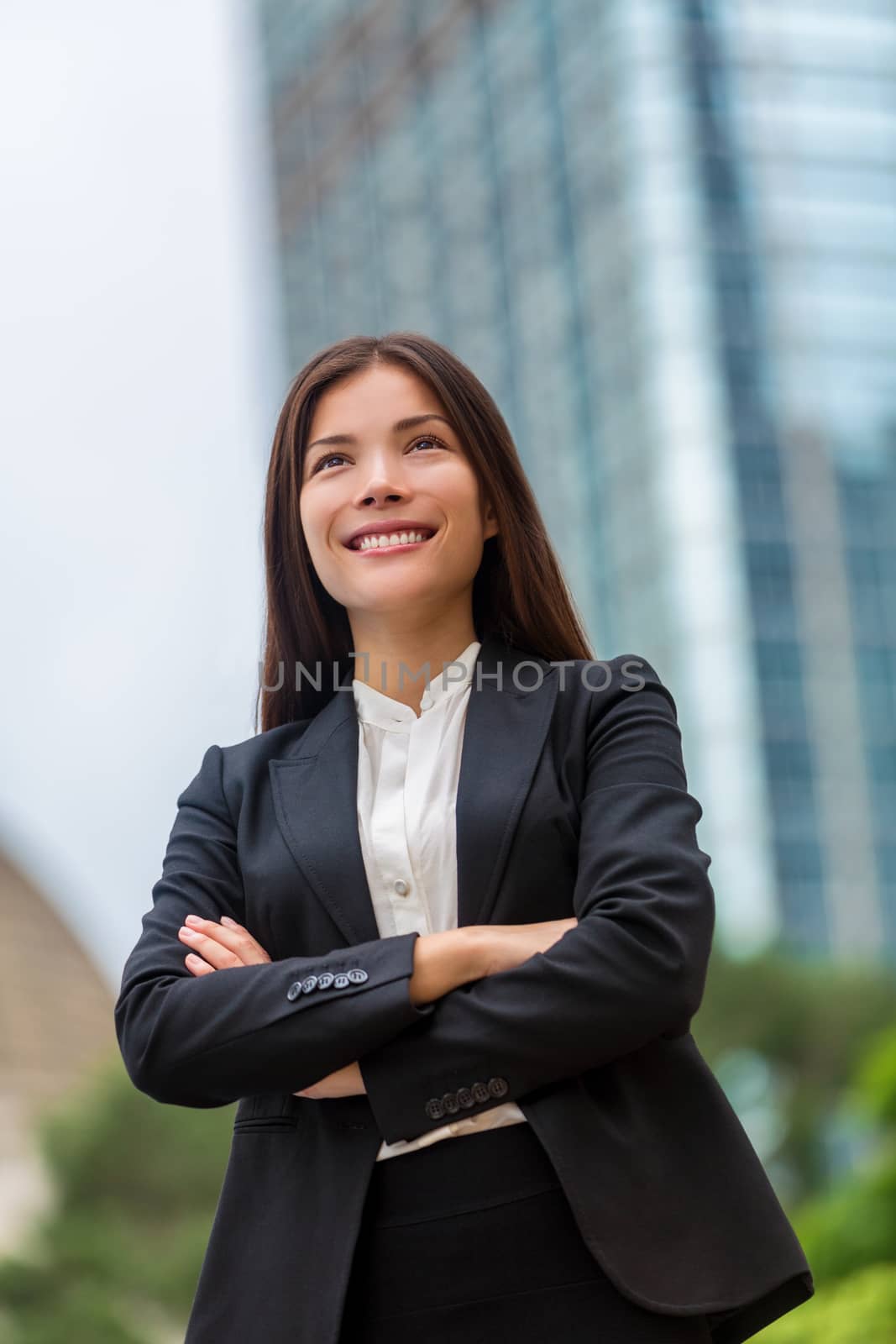 Asian businesswoman confident in Hong Kong. Businesswoman standing outdoor with city urban background in suit cross-armed. Young multiracial Chinese Asian / Caucasian professional in Hong Kong by Maridav