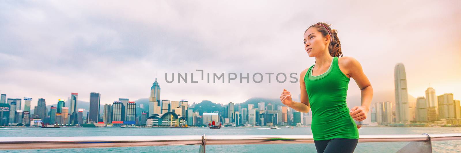 Hong Kong city China travel sightseeing fitness woman jogging at skyline banner panorama . Healthy active lifestyle panoramic view of urban landscape.