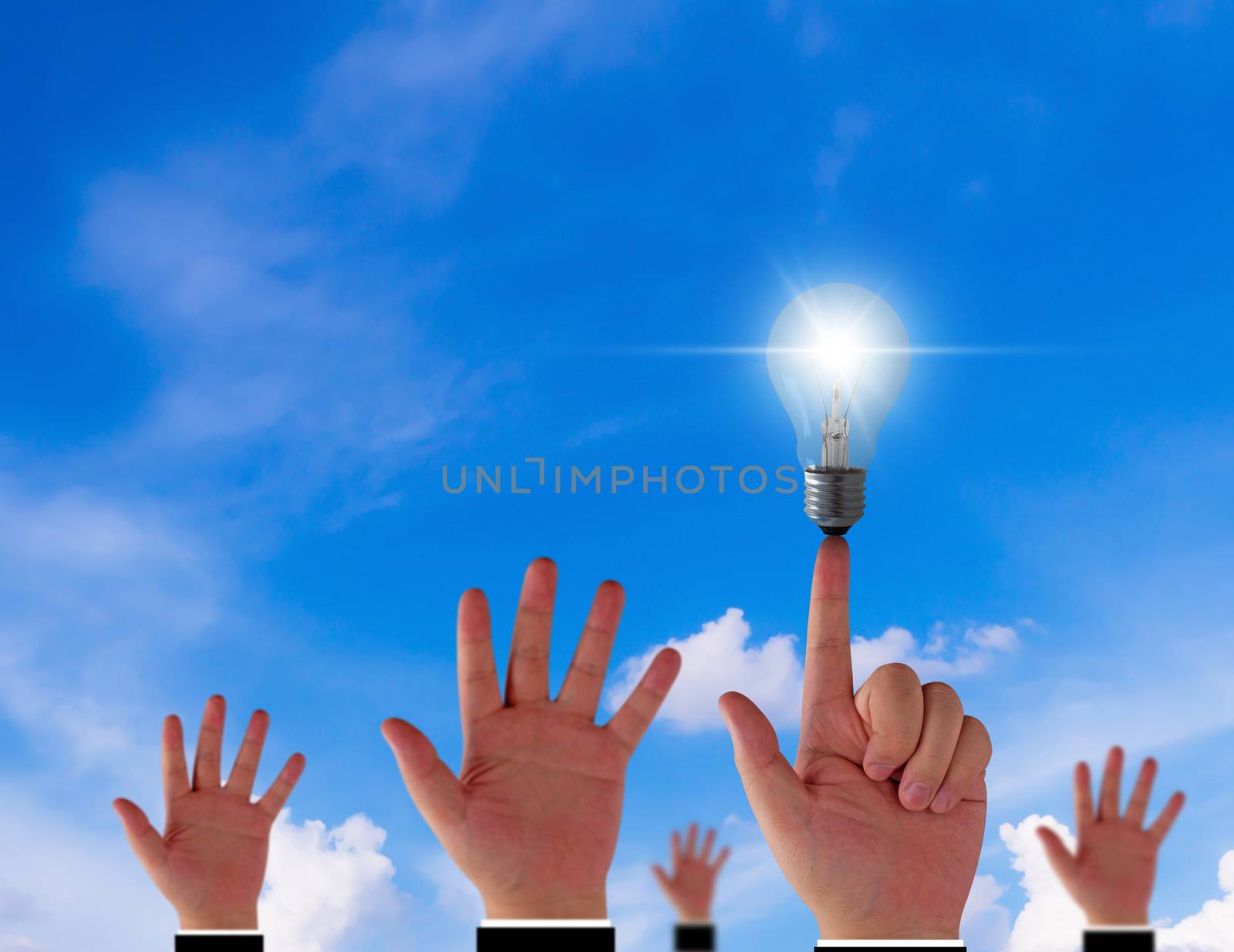 Think different concept, hand and light bulb on blue sky background