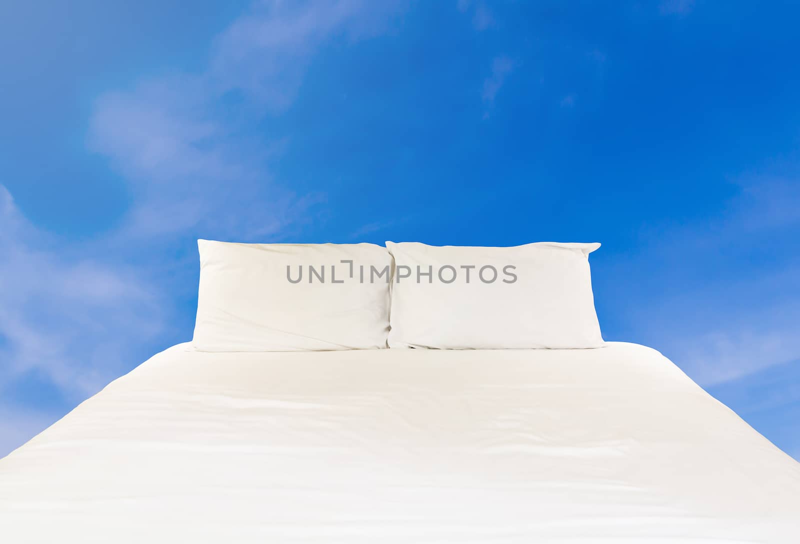 Clean bed on blue sky, relaxation and comfortable concept 