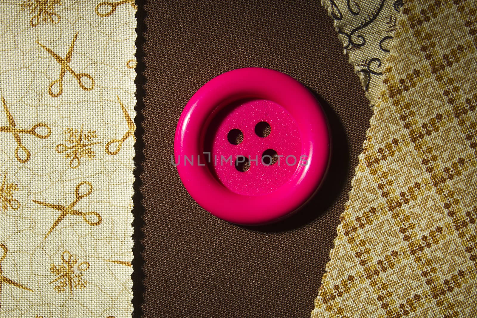 Button and fragments of fabric on a wooden table