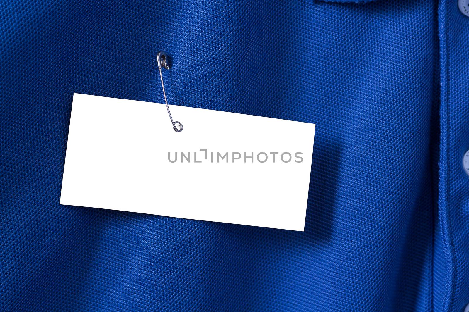 White paper tag, label on blue shirt with brooch