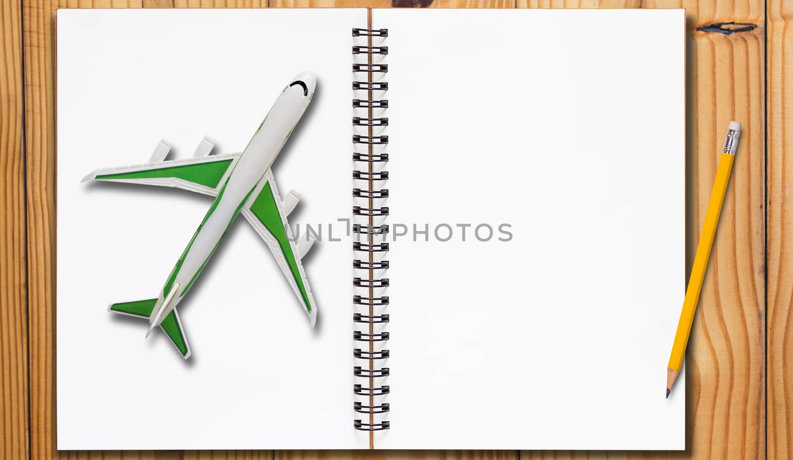 Travel concept, open notebook and yellow pencil on wooden table background