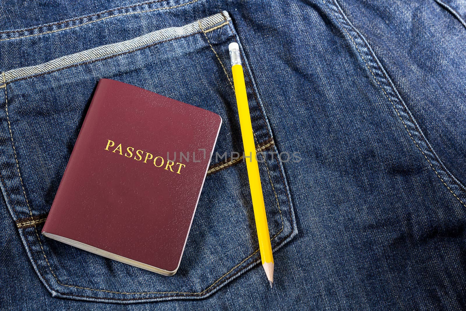 Passport and yellow pencil on jean background, traveling concept