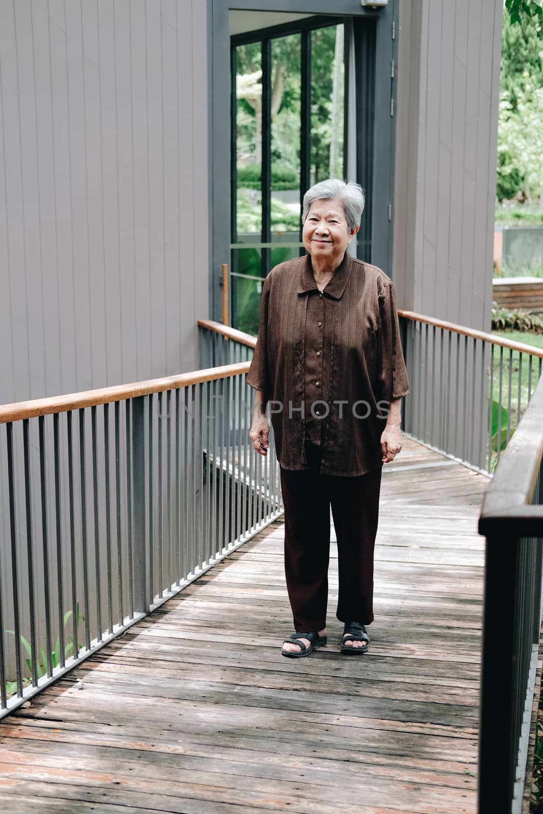 asian elder female woman resting relaxing on balcony terrace at home. elderly senior leisure lifestyle