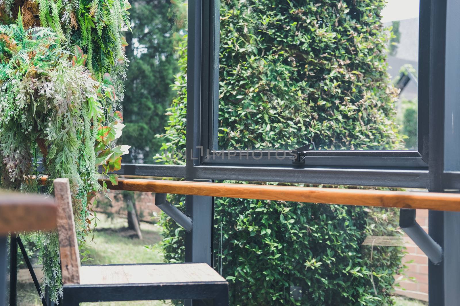 fake green leaves plant decorating near window in living room home interior
