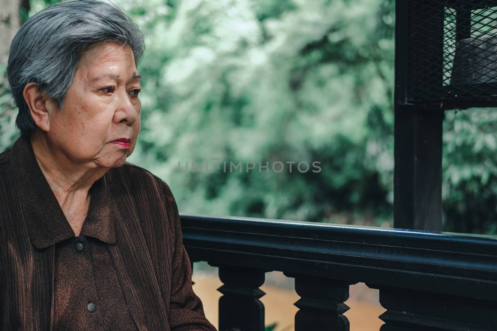 asian elder female woman resting relaxing on balcony terrace at home. elderly senior leisure lifestyle