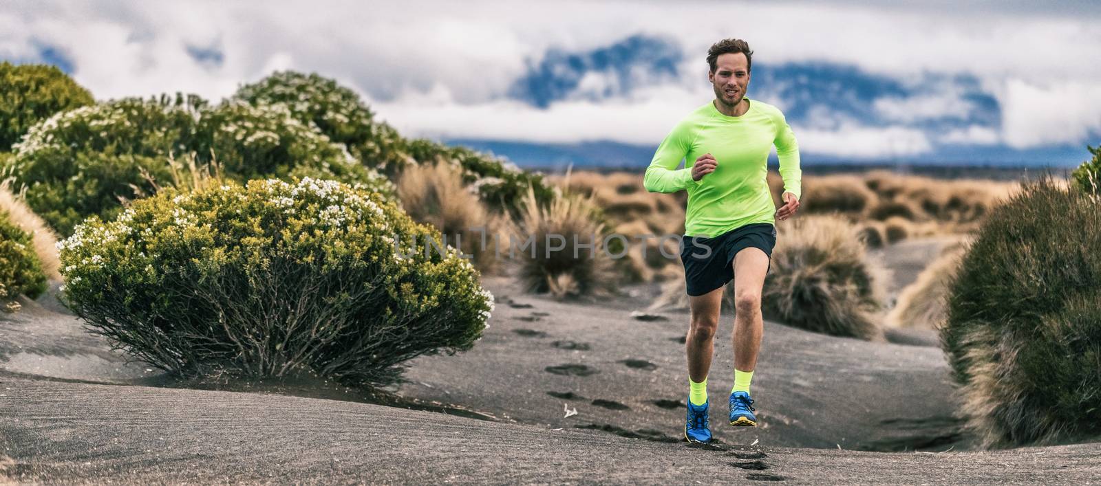 Trail run man athlete runner running marathon in desert landscape mountain hills summer background. Fitness and sports lifestyle by Maridav