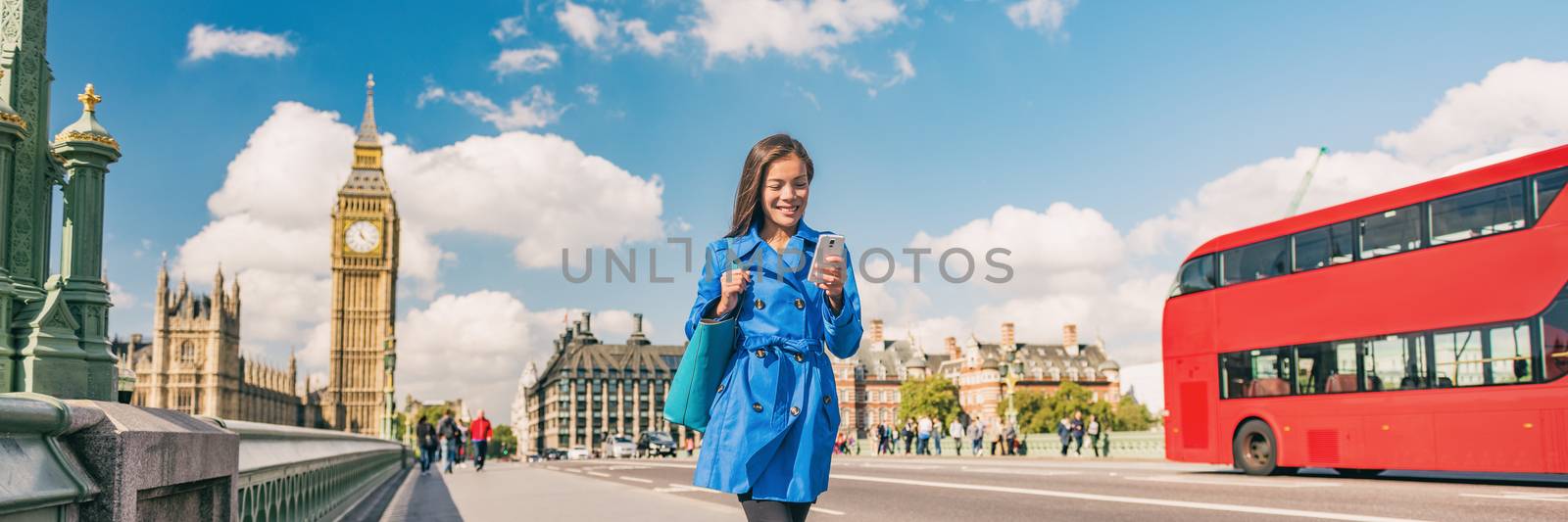 London city commute panoramic background of woman walking to work using phone. People lifestyle tourist. Businesswoman commuting on Westminster bridge street. Europe travel, England, United Kingdom.