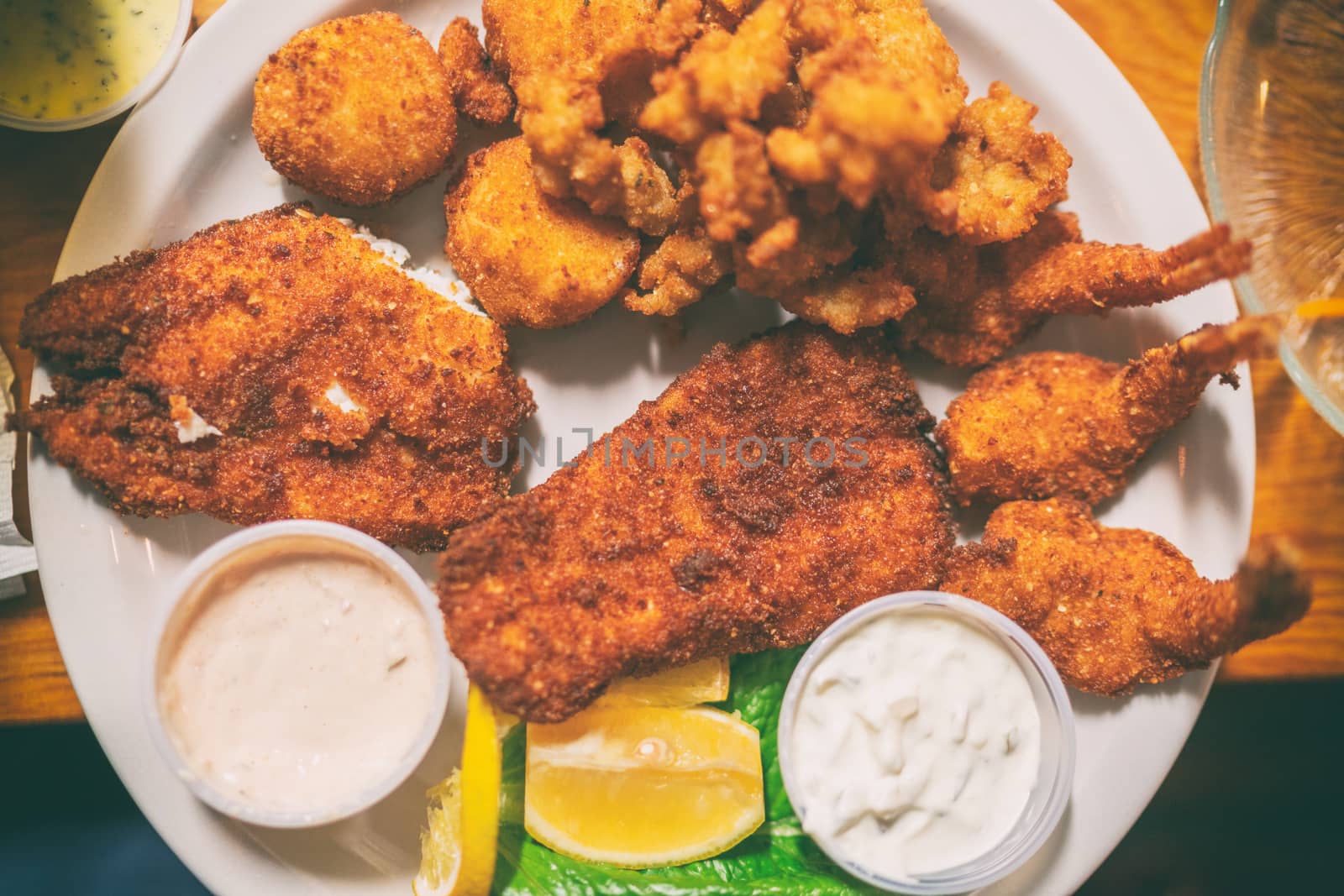 Fried seafood platter top view of local dish from Key West, Florida, Conch fritters, cod fish in oily batter fry by Maridav