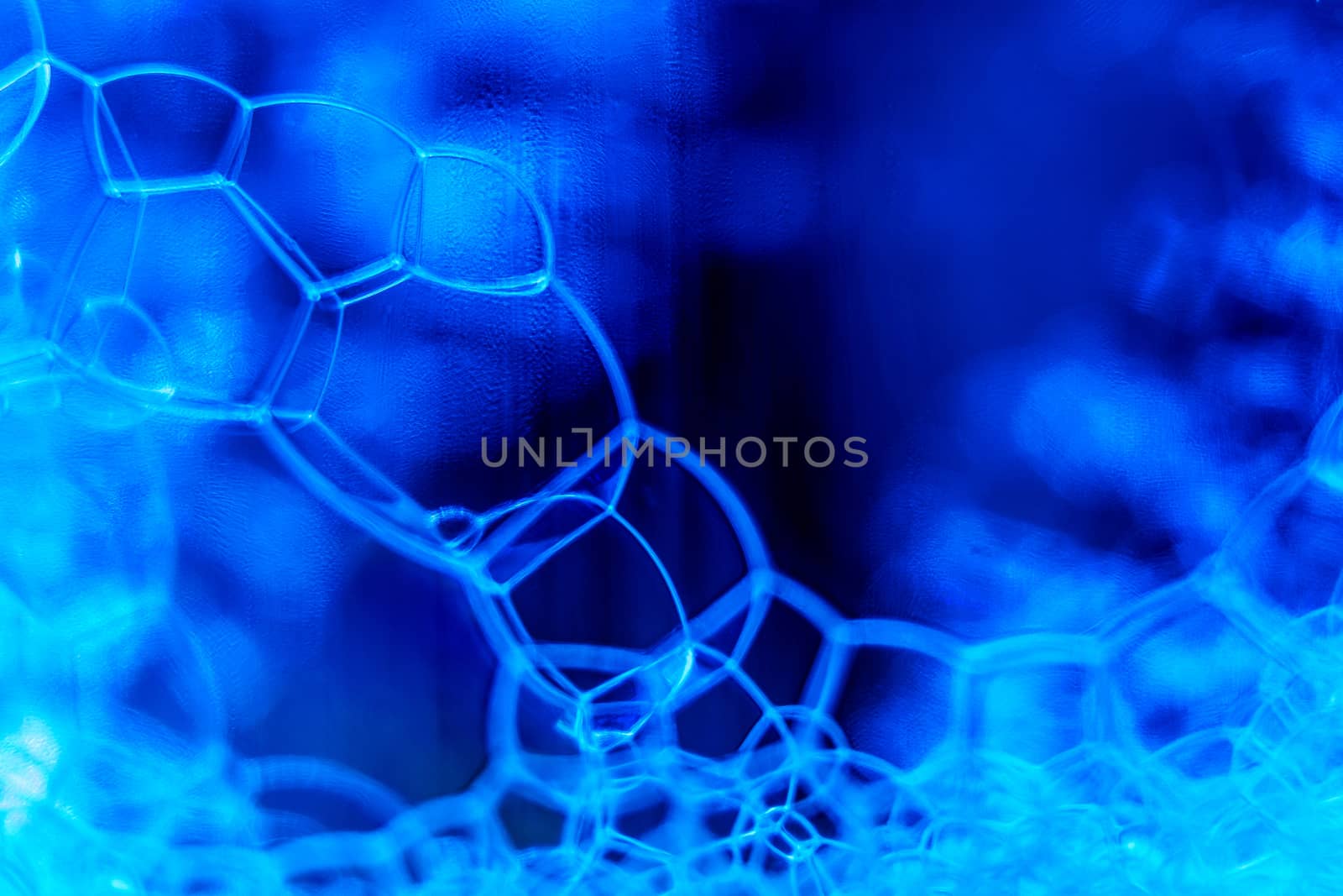 Abstract macro clean blue foam shot background of soap bubbles