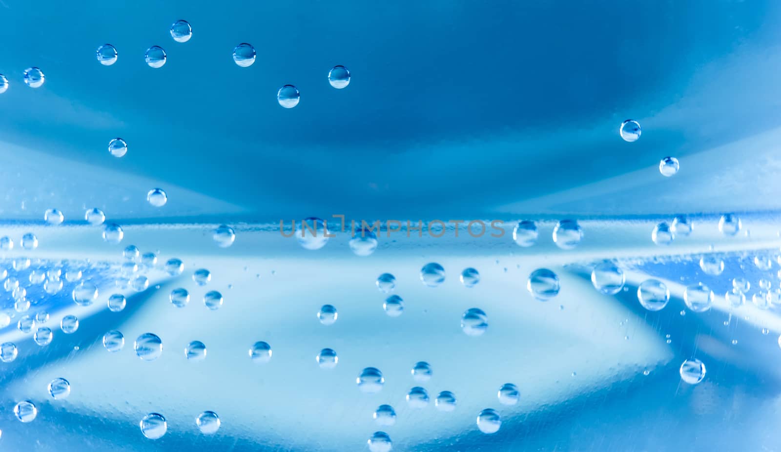 Macro shot of water with bubbles inside a plastic bottle with light and colors effects by robbyfontanesi