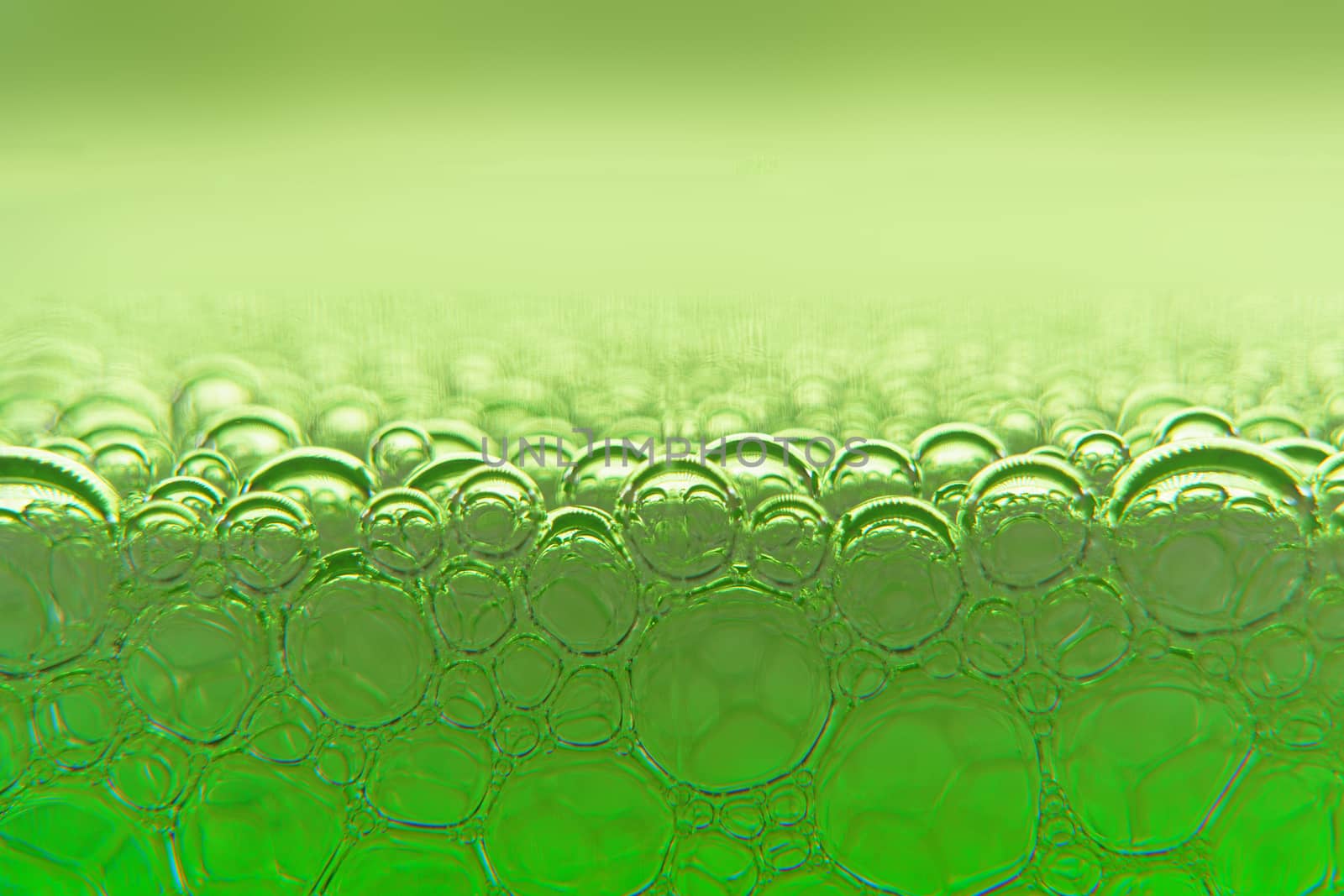 Abstract macro clean green foam shot background of soap bubbles with light and color reflections effects