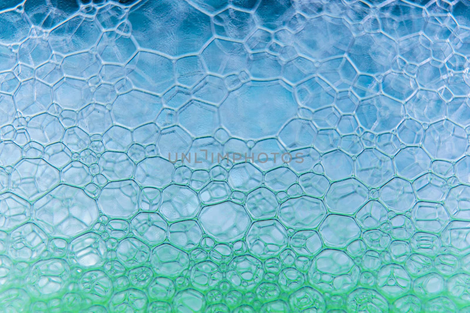 Abstract macro clean blue foam shot background of soap bubbles with light and color reflections effects