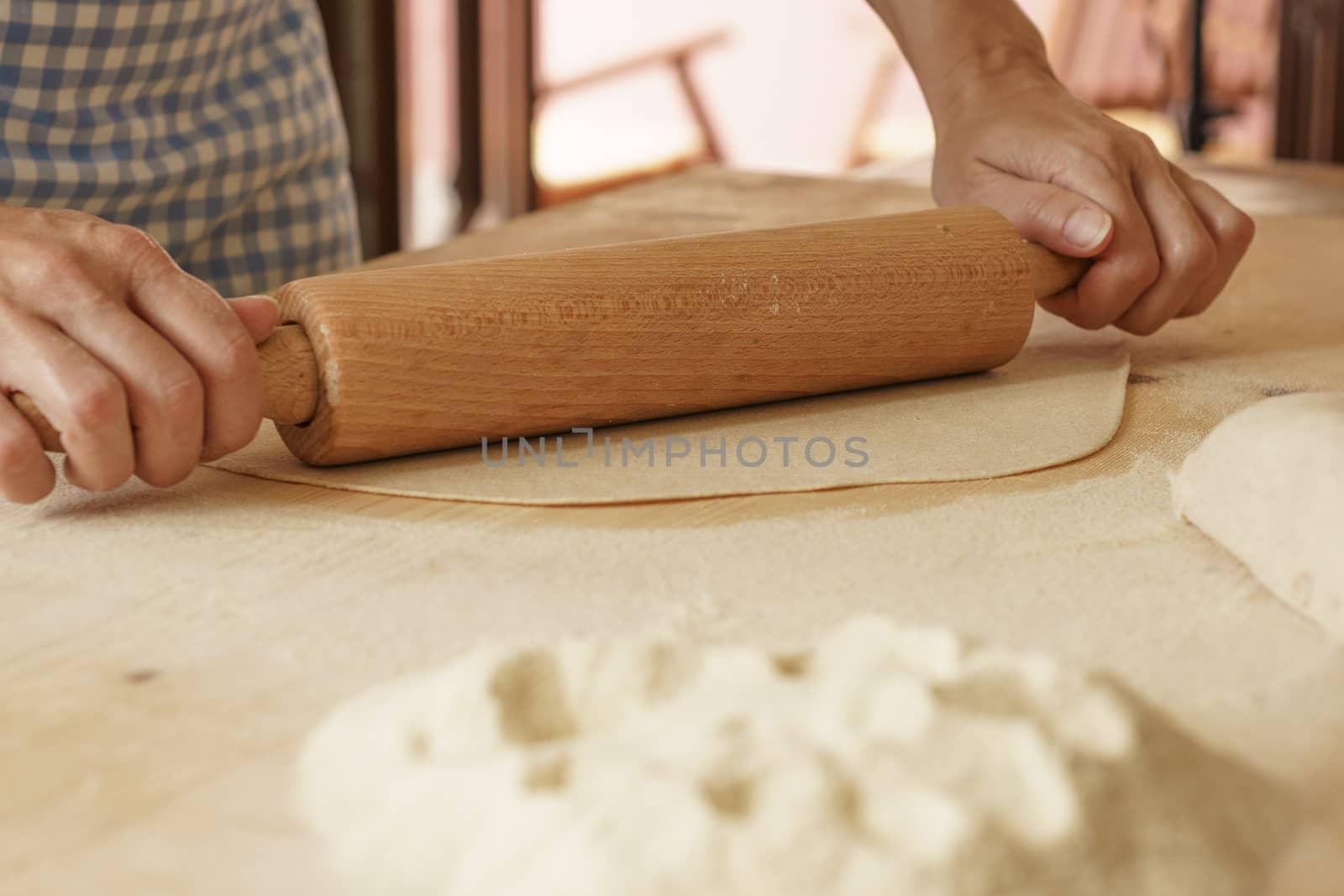 Close up process of homemade vegan farfalle pasta with durum wheat flour. The cook uses a rolling pin to stretch the dough, traditional Italian pasta, the woman cooks the food in the kitchen