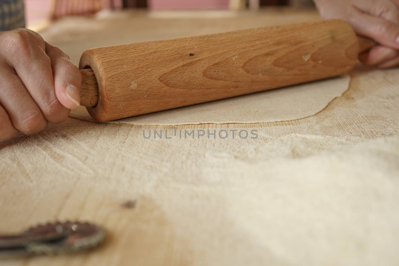 Close up process of homemade vegan farfalle pasta with durum wheat flour. The cook uses a rolling pin to stretch the dough, traditional Italian pasta, the woman cooks the food in the kitchen