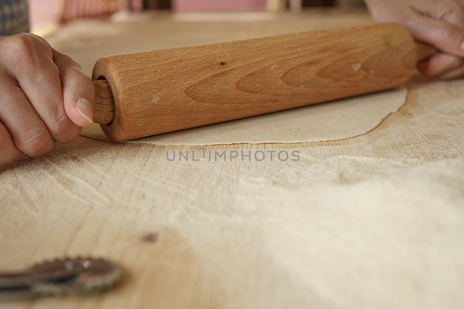 Close up process of homemade vegan farfalle pasta with durum wheat flour. The cook uses a rolling pin to stretch the dough, traditional Italian pasta, the woman cooks the food in the kitchen by robbyfontanesi