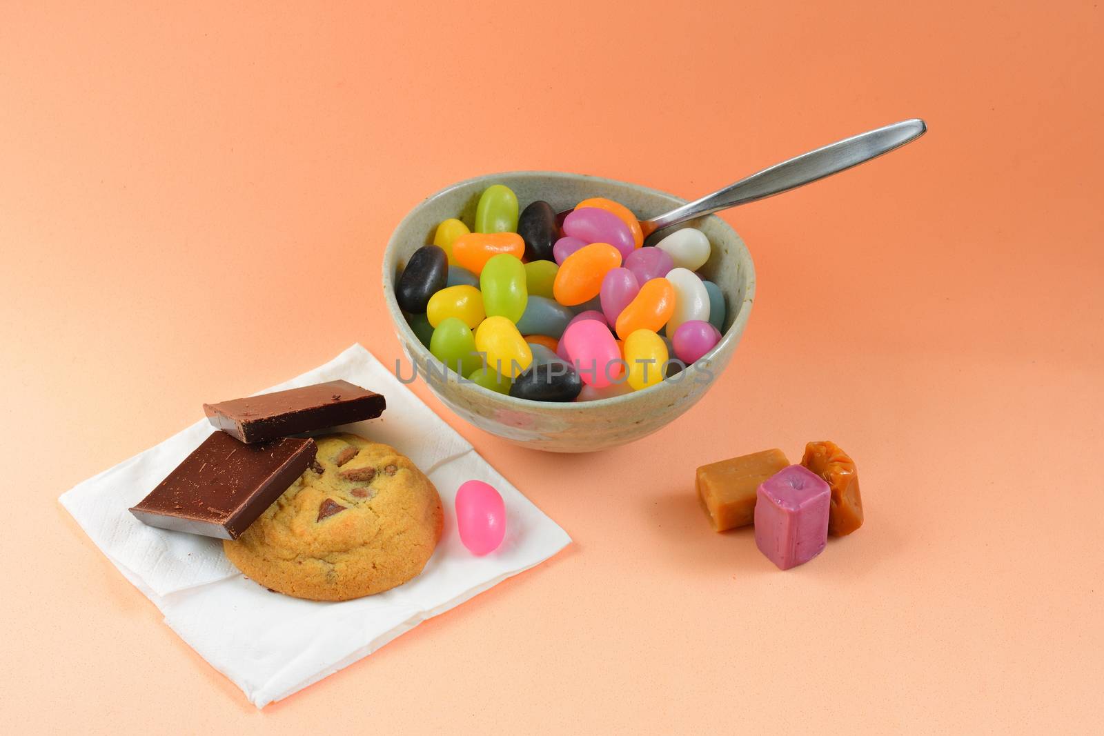 A close-up photo of a meal consisting of some colorful jelly beans, mixed sweets and cookies. Concept of unhealthy diet by Marshalkina