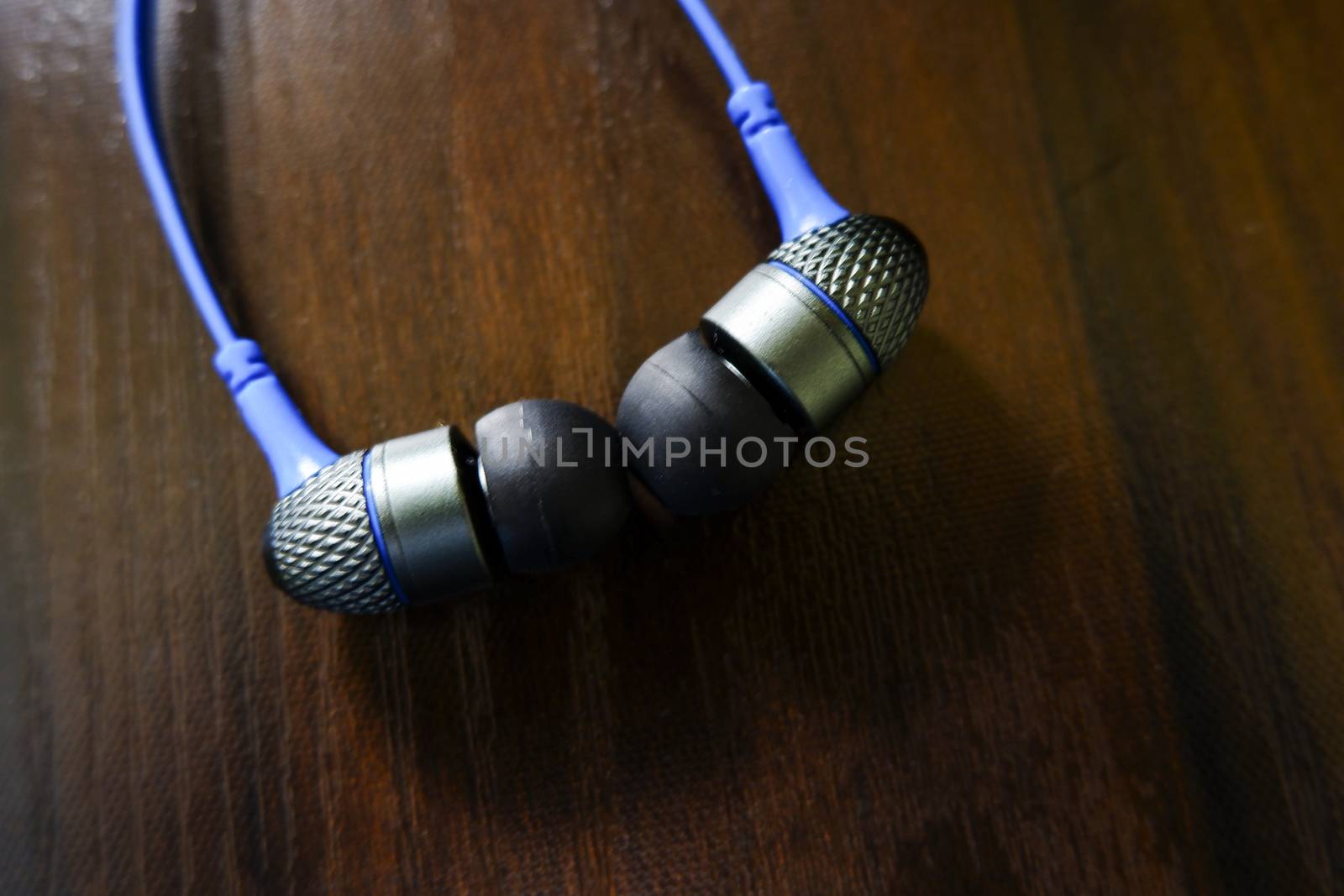 a closeup view of headphone earbuds isolated on wooden texture table