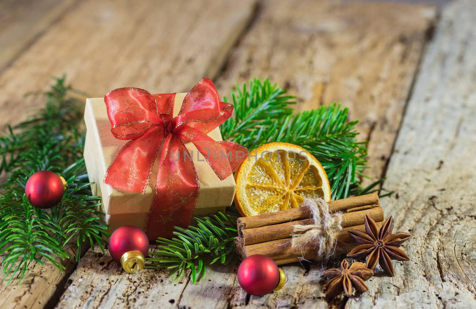 Christmas gift box with red ribbon and decoration on wooden table