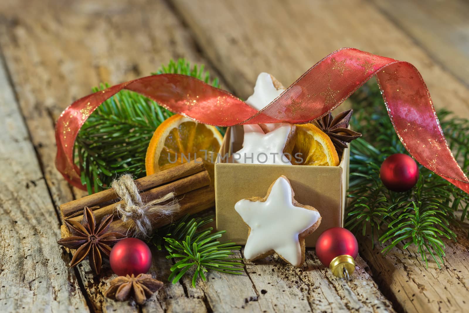 Christmas star biscuits, spices and ornaments on wooden table