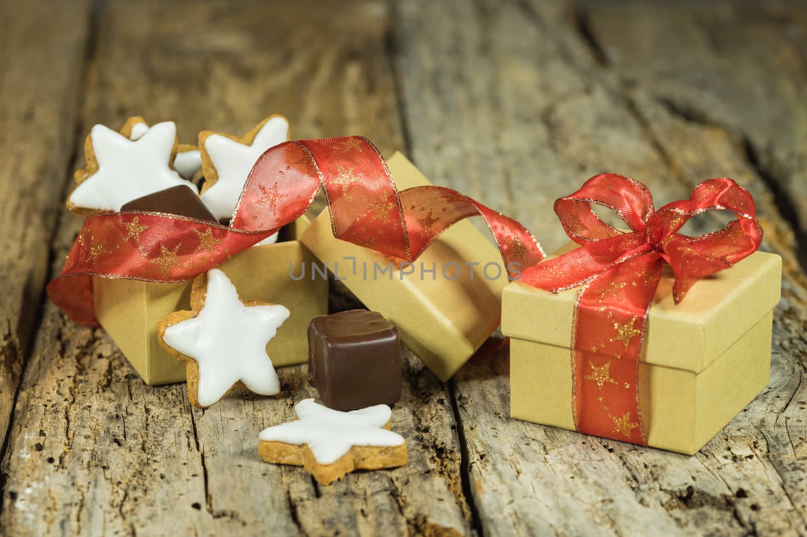 Christmas composition of star cookies and sweet chocolate in gift box on wooden table