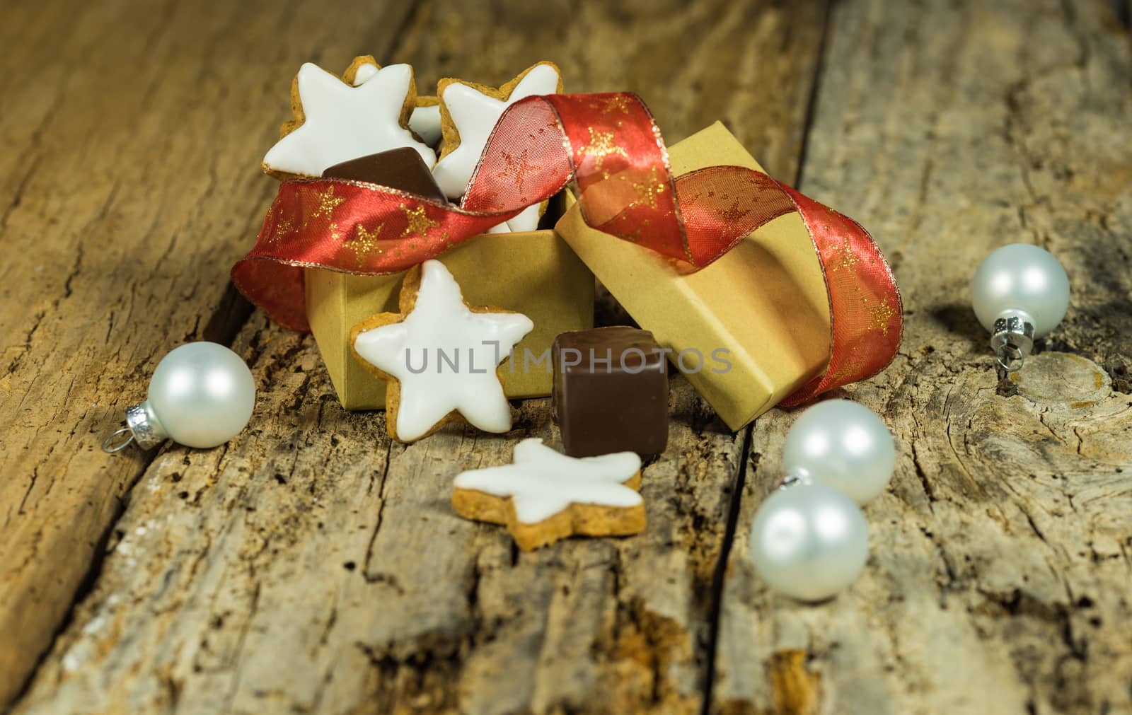 Sweet Christmas present with star biscuits and chocolate on wooden table