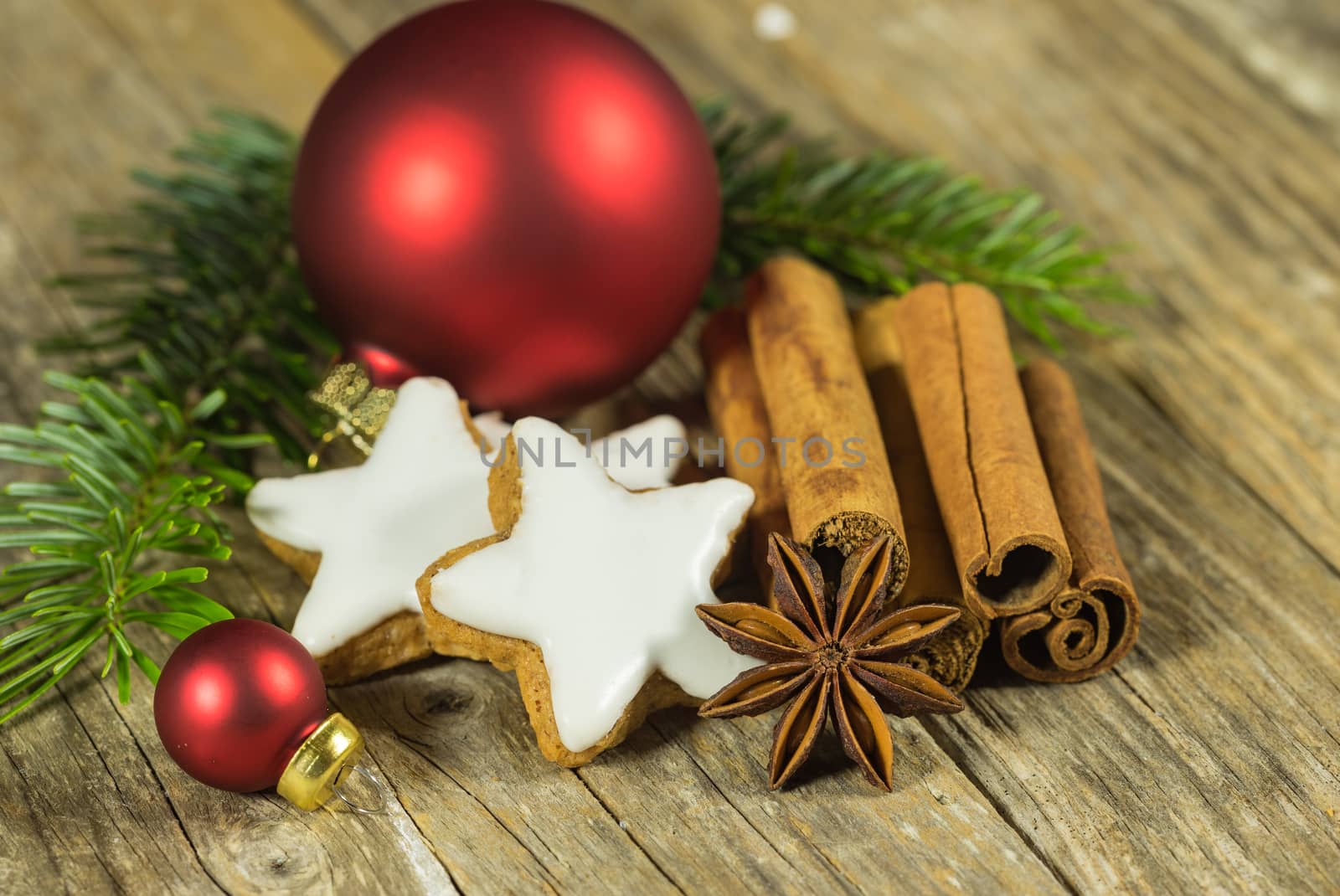 Christmas still life with star biscuit, spices and ornaments on wooden table