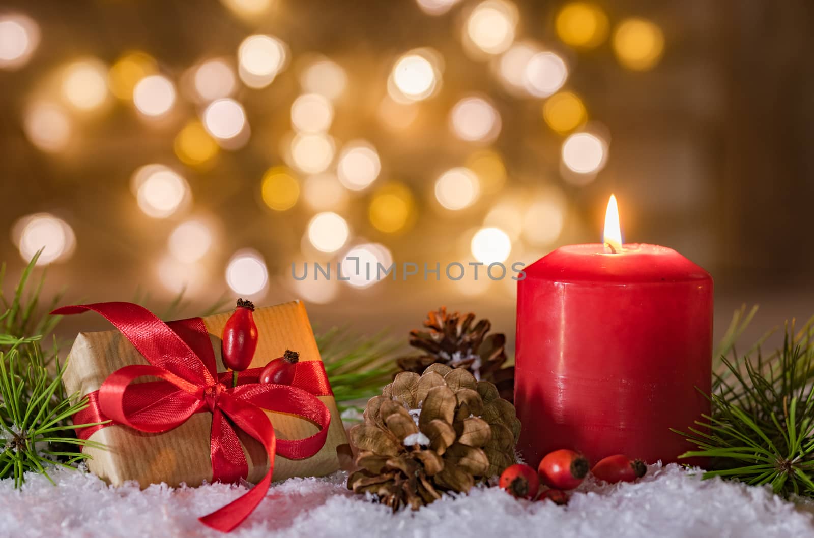Merry Christmas decoration advent with gift and burning red candle blurred background 