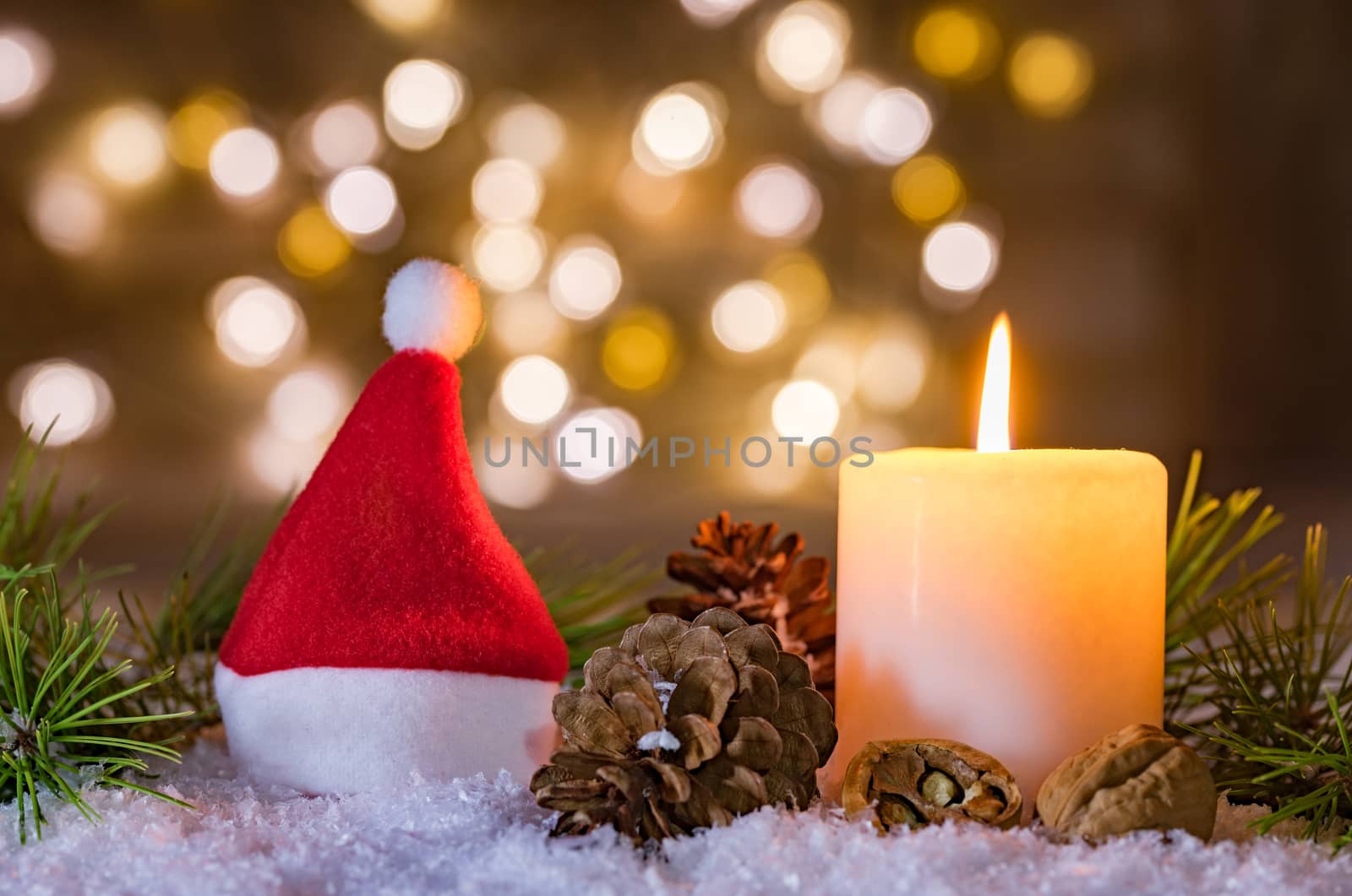 Red Santa Claus hat with candle and blurred lights background