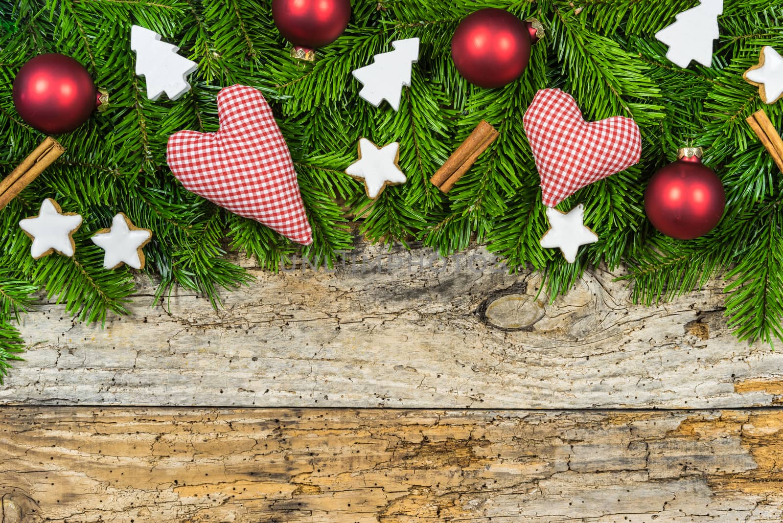 Xmas hearts and gift with ornaments and fir branches on wood background