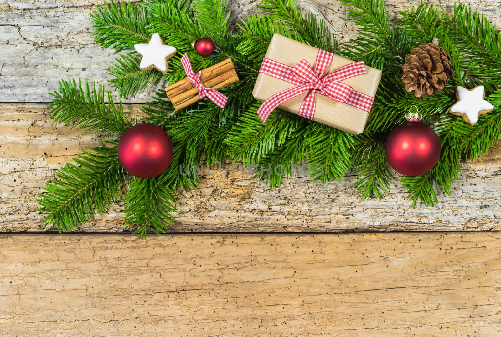 Traditional Christmas decoration with fir tree branch, gift box and ornaments on rustic wood, copy space