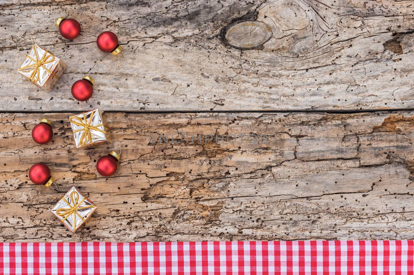 Christmas with decorations and red checkered fabric border on old wood background, copy space