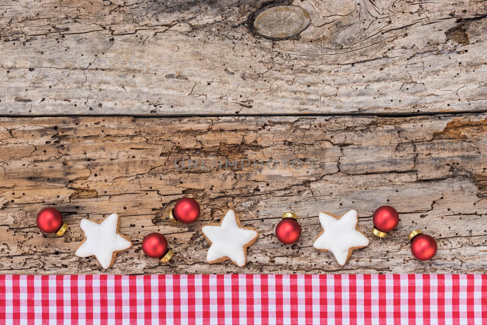 Christmas border with ornaments on rustic wood background, top view