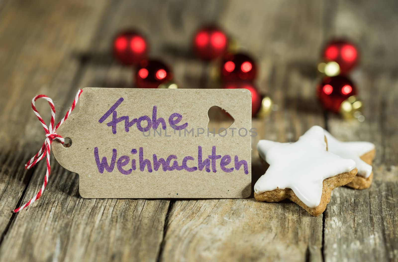 Tag with handwritten greeting in german, Frohe Weihnachten, means Merry Christmas