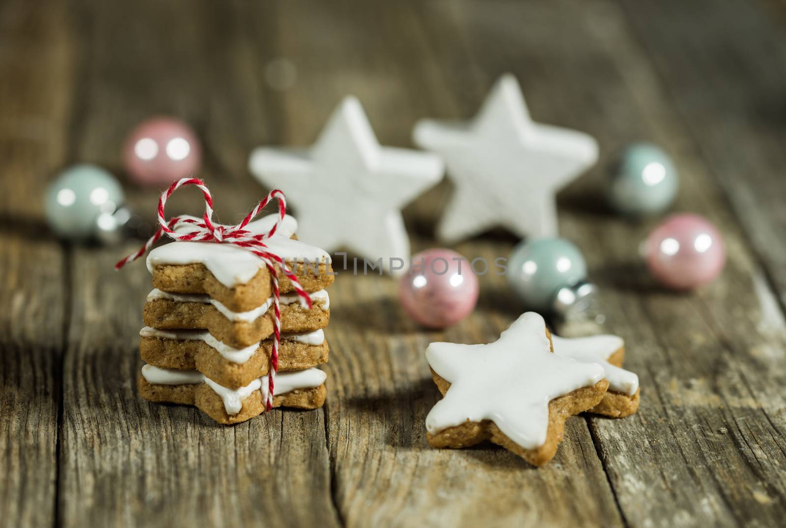 Compositon of christmas decorations with star shaped biscuits on wooden table