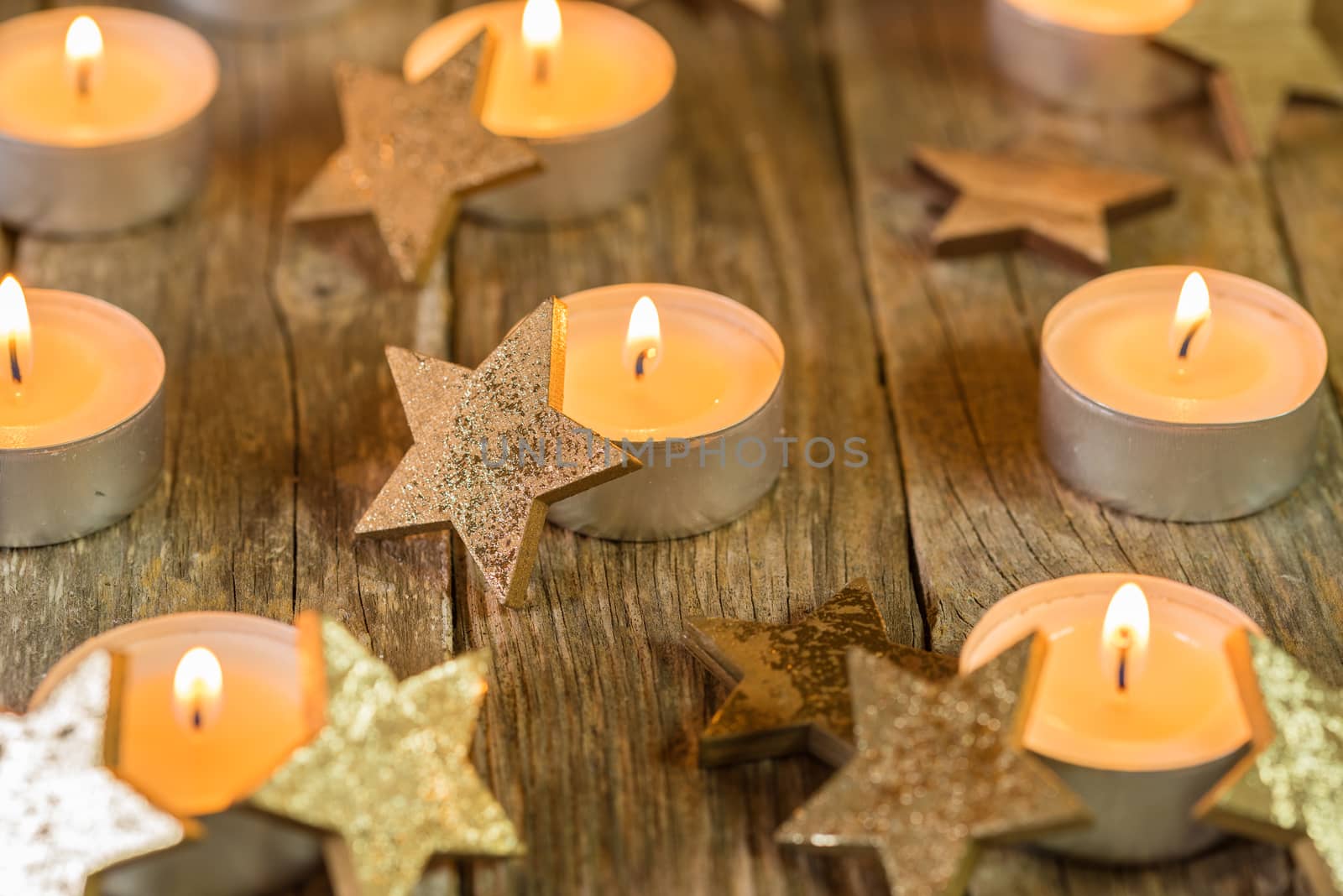 Burning Christmas candles with golden star shape ornaments and festive atmosphere