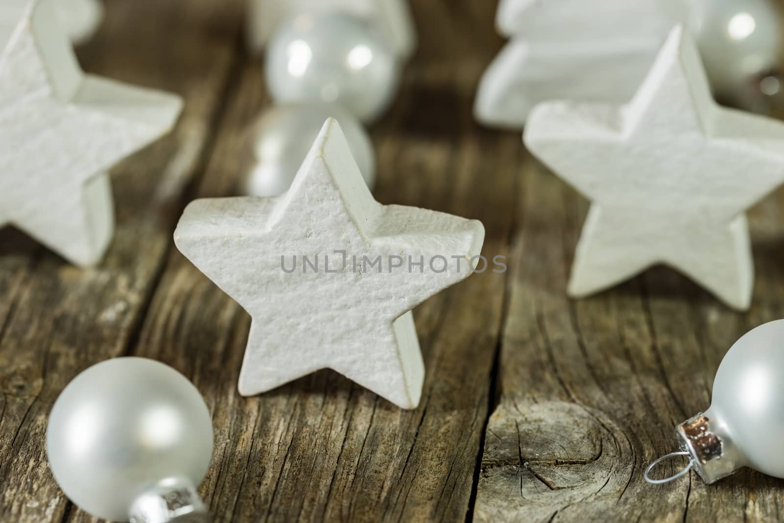 White wooden christmas star shapes and baubles decoration on wooden table